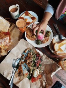 Top view of a traditional Malaysian breakfast spread with various local delicacies and drinks in a café.