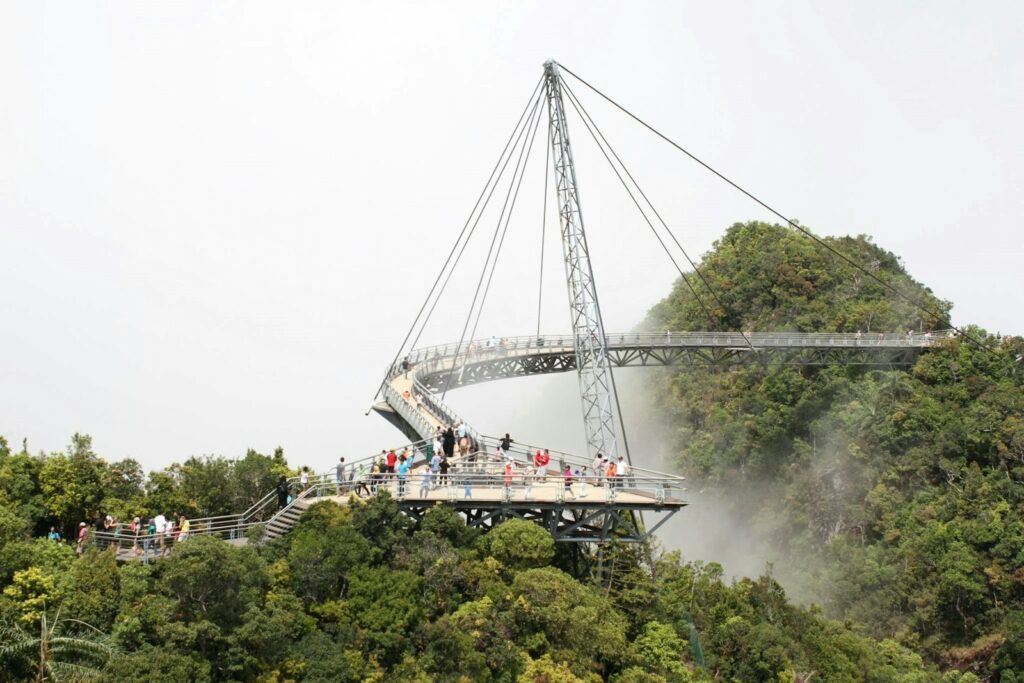 Curved pedestrian bridge on a lush, misty mountainside