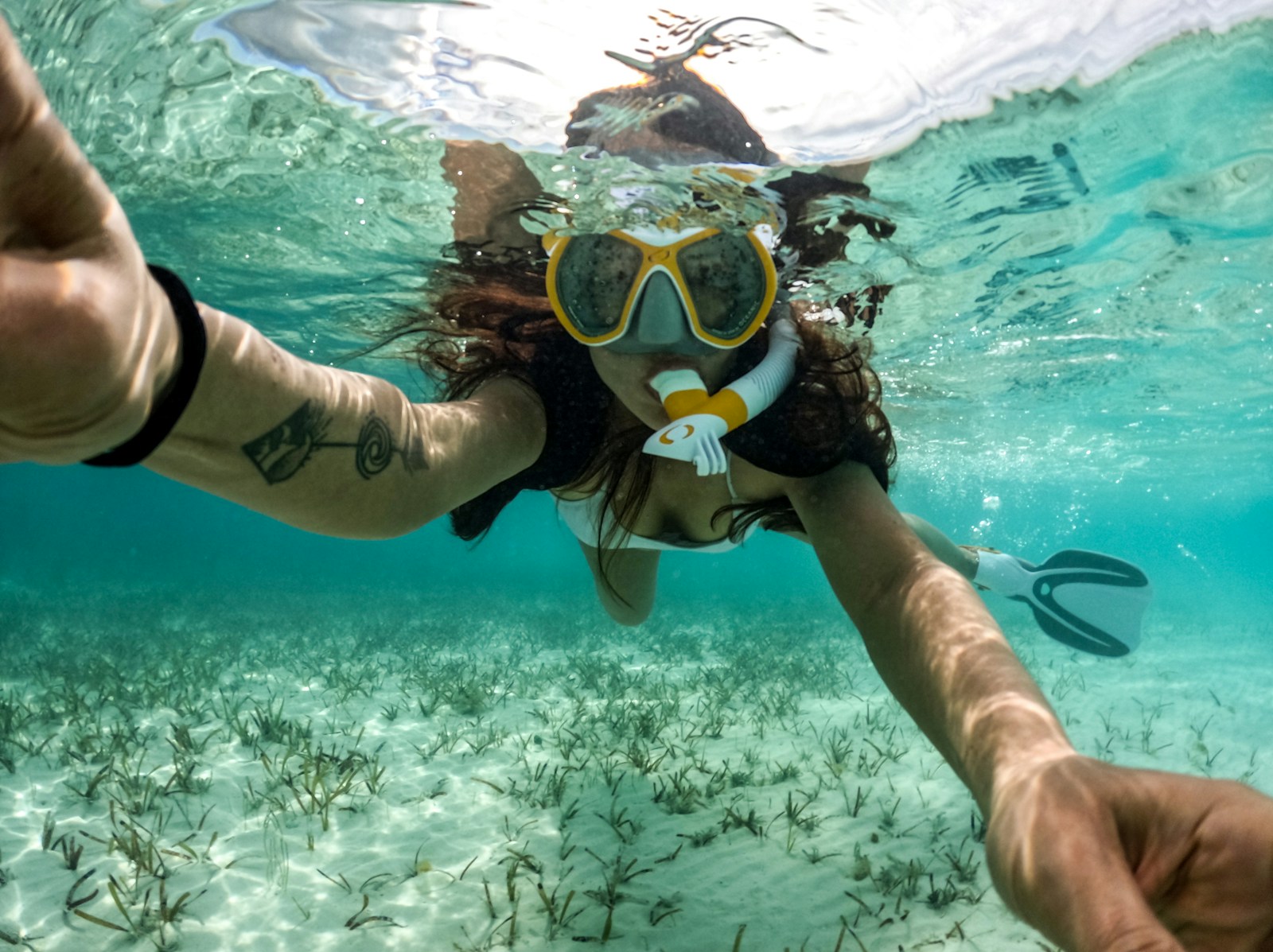 Woman snorkeling in the clear, blue ocean.