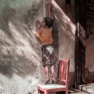 man in black shorts standing on red wooden seat