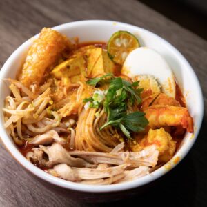 a bowl of food with noodles, meat, and vegetables